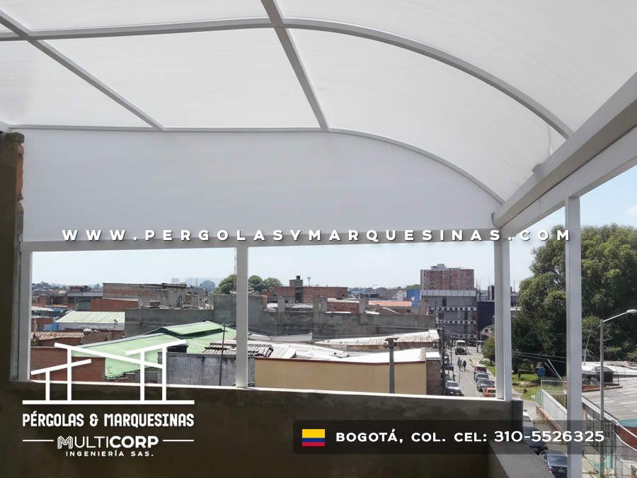 Cubierta en policarbonato curva para balcón semicerrado con vista urbana en edificio de Bogotá, Colombia. Multicorp Ingeniería SAS. Cubierta en policarbonato curva para balcón semicerrado con vista urbana en edificio de Bogotá, Colombia. Multicorp Ingeniería SAS.