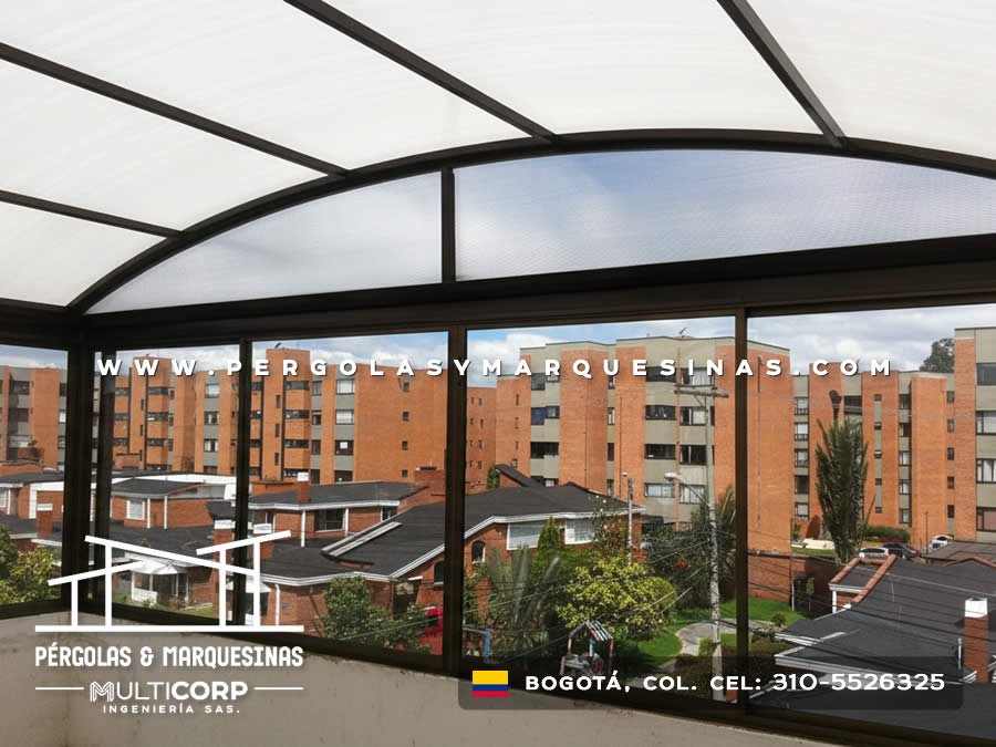 Pérgola metálica en acero negro con policarbonato y cerramiento de vidrio para balcón de edificio en Bogotá. Multicorp Ingeniería SAS.