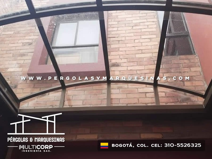 Techo curvo translúcido con estructura negra vista desde interior de balcón residencial en Bogotá, Colombia. Multicorp Ingeniería SAS.