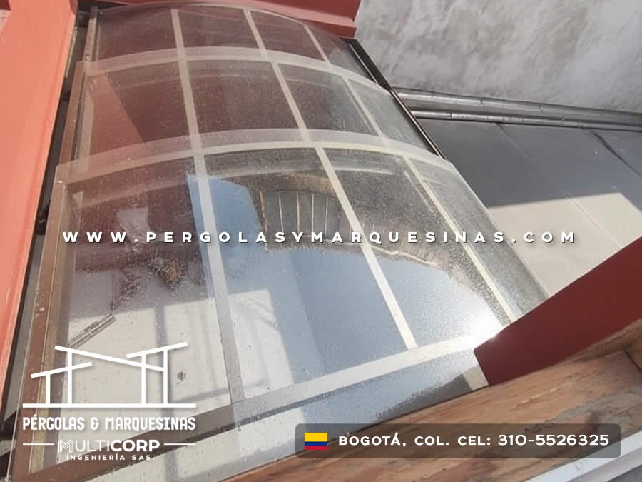 Domo curvo transparente con estructura blanca montado sobre patio interior residencial en Bogotá, Colombia. Multicorp Ingeniería SAS.