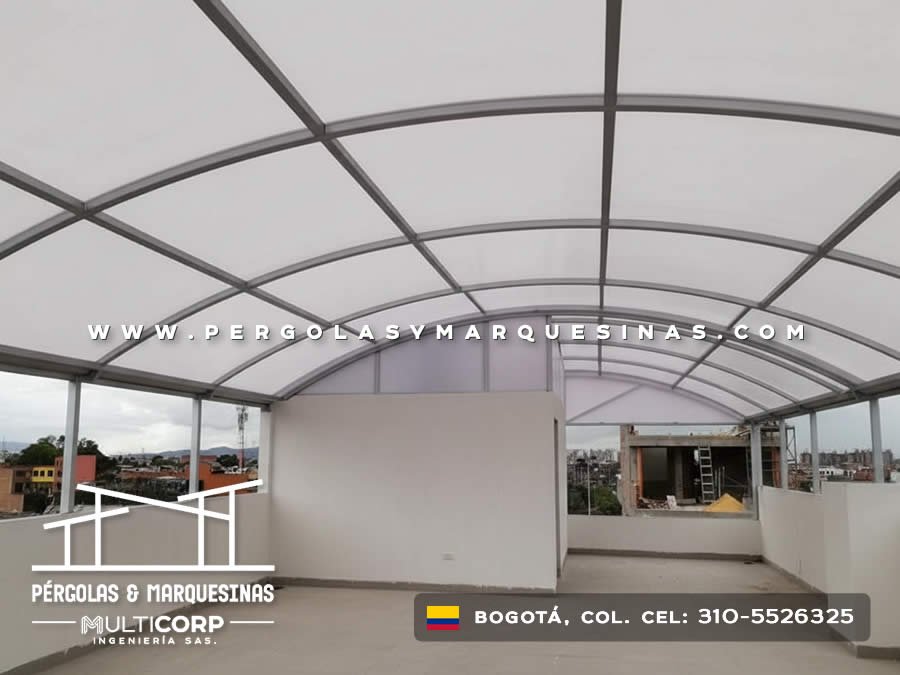 Cubierta curva de policarbonato con perfiles metálicos grises para terraza residencial en Bogotá, Colombia. Multicorp Ingeniería SAS.