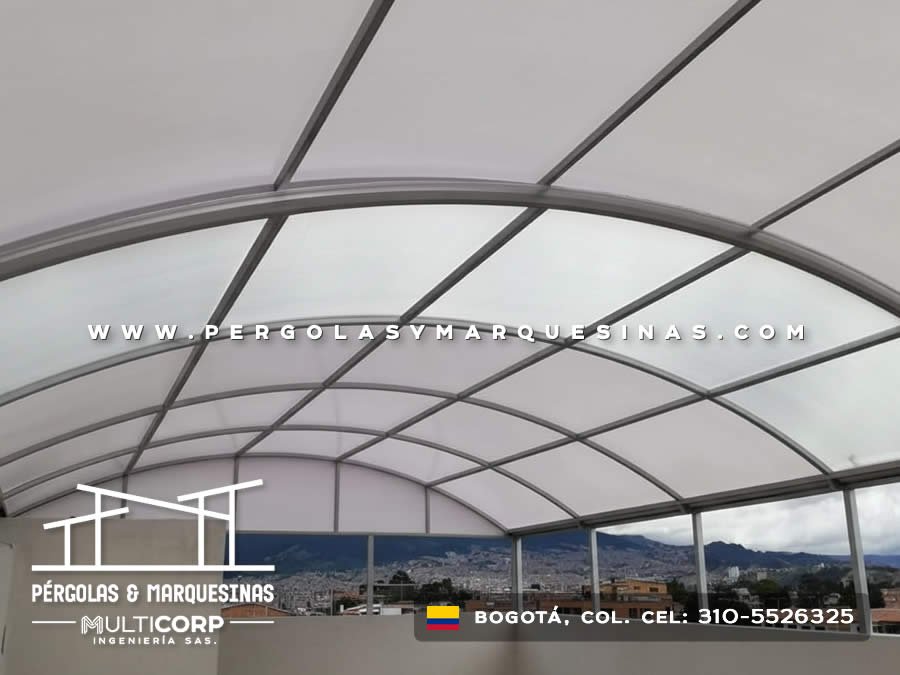 Techo curvo translúcido con armazón metálico gris instalado en terraza de edificio en Bogotá, Colombia. Multicorp Ingeniería SAS.