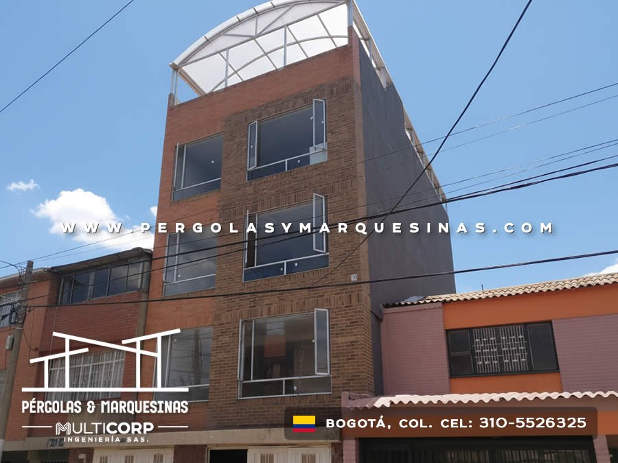 Domo curvo de policarbonato con estructura metálica blanca en fachada de edificio en Bogotá, Colombia. Multicorp Ingeniería SAS.