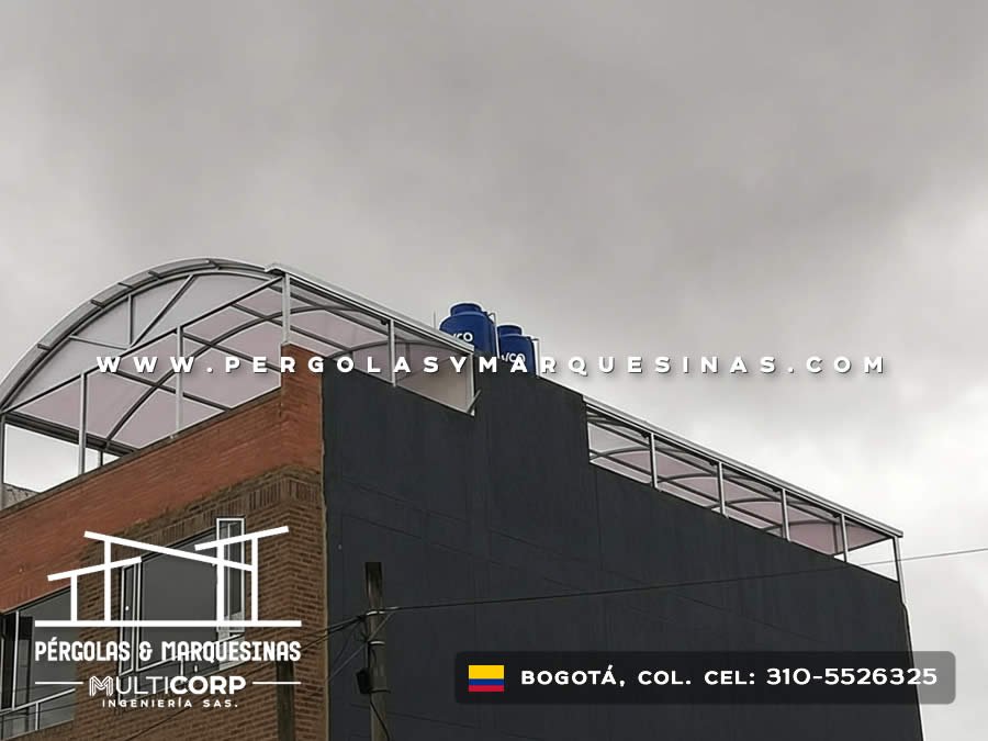 Estructura curva de policarbonato con perfiles metálicos grises en azotea de edificio en Bogotá, Colombia. Multicorp Ingeniería SAS.