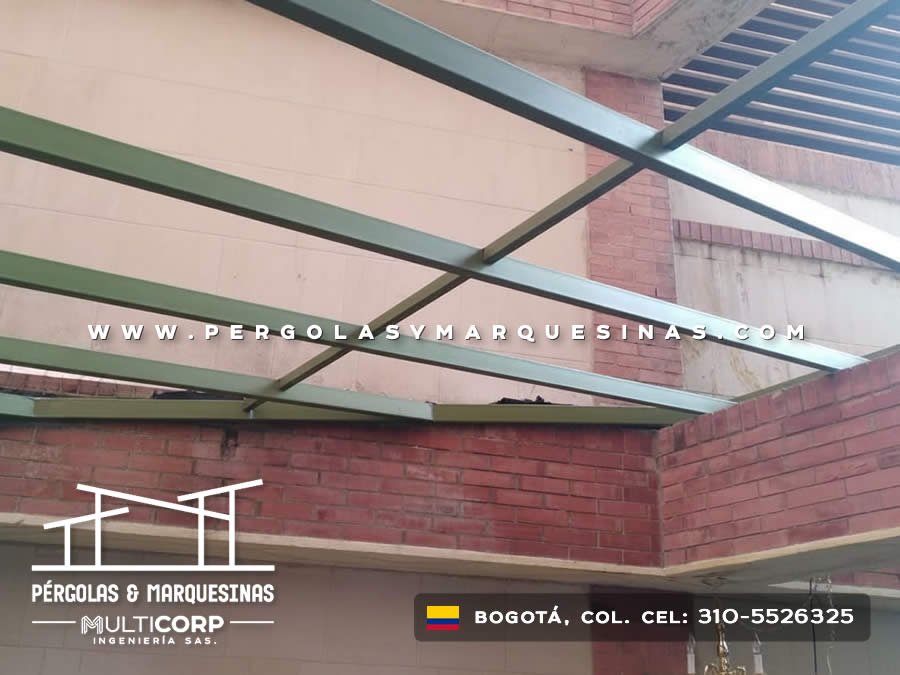 Techo de policarbonato con vigas metálicas verdes anclado en muros de ladrillo en Bogotá, Colombia. Multicorp Ingeniería SAS.