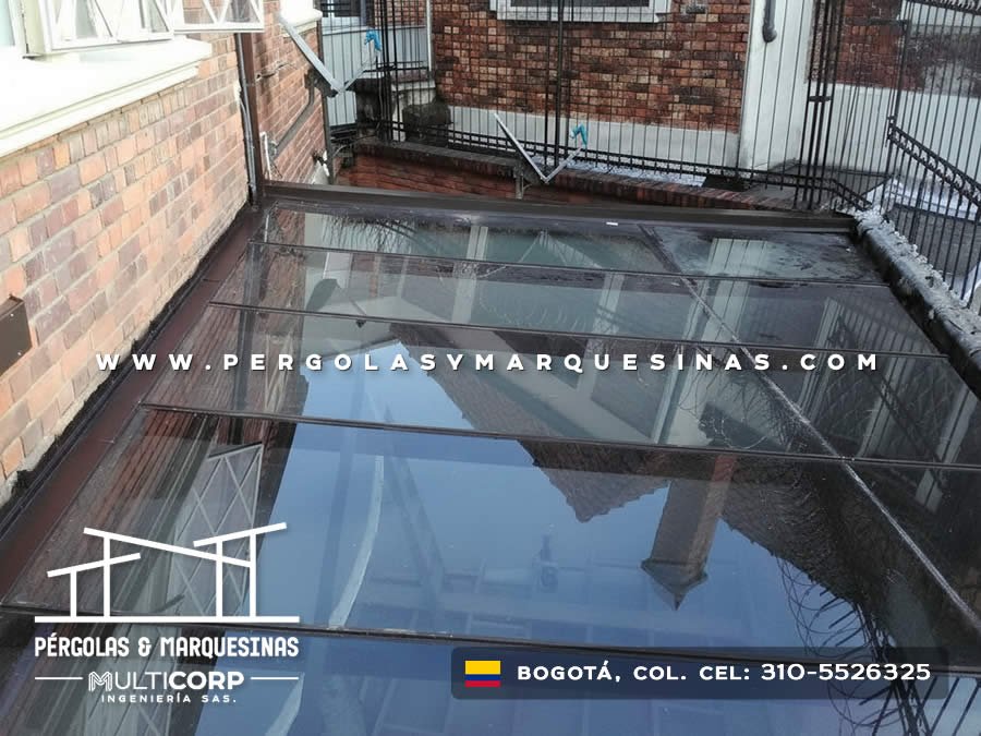 Techo de vidrio templado con perfilería metálica gris instalado en balcón de edificio en Bogotá, Colombia. Multicorp Ingeniería SAS.