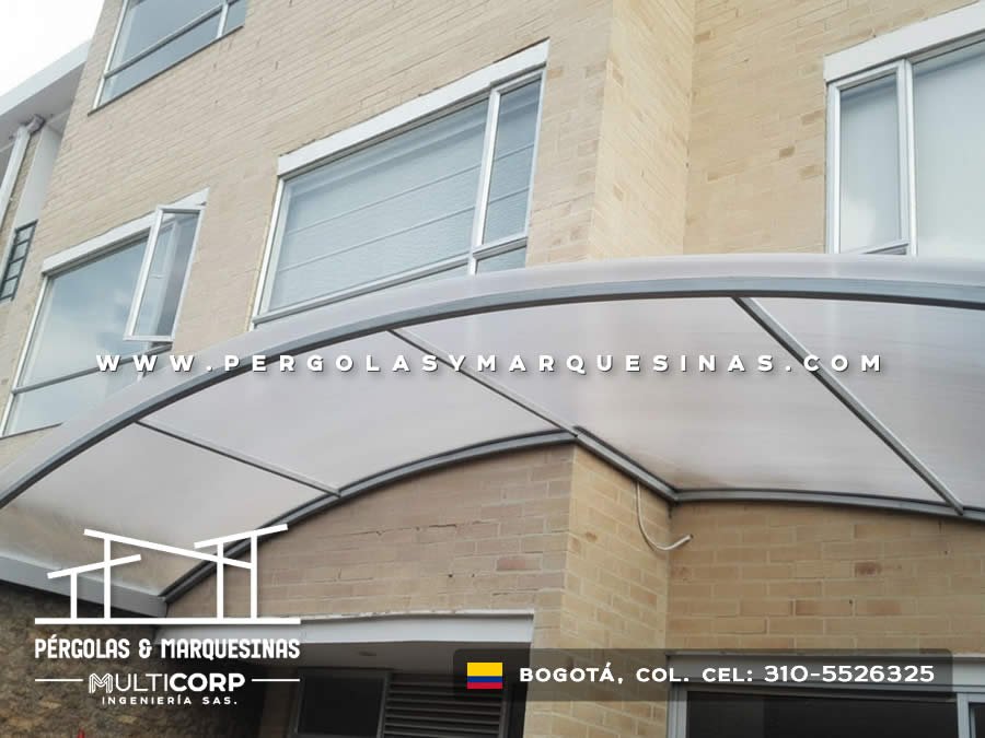 Marquesina curva de policarbonato con marco metálico gris para fachada residencial en Bogotá, Colombia. Multicorp Ingeniería SAS.