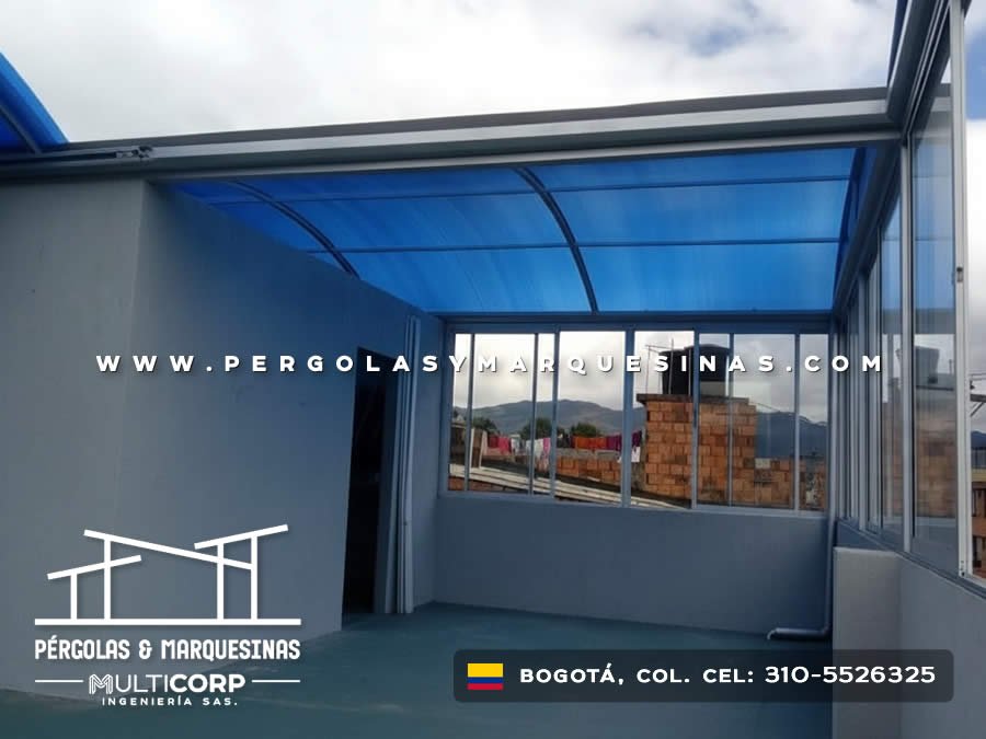 Cerramiento con techo curvo azul y ventanales de aluminio para terraza en Bogotá, Colombia. Multicorp Ingeniería SAS.