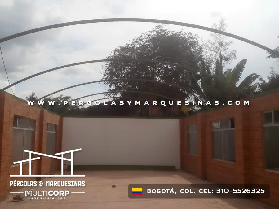 Cubierta curva translúcida con arcos metálicos para patio central de colegio en Bogotá, Colombia. Multicorp Ingeniería SAS.