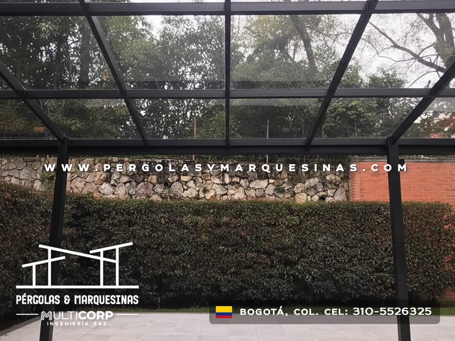 Pérgola de vidrio con perfiles metálicos negros instalada sobre terraza residencial en Bogotá, Colombia. Multicorp Ingeniería SAS.