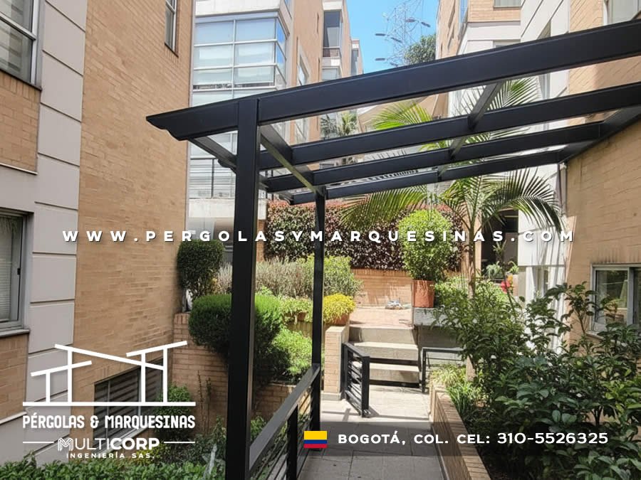 Pérgola metálica negra con vigas voladizas en zona verde de conjunto residencial en Bogotá, Colombia. Multicorp Ingeniería SAS.