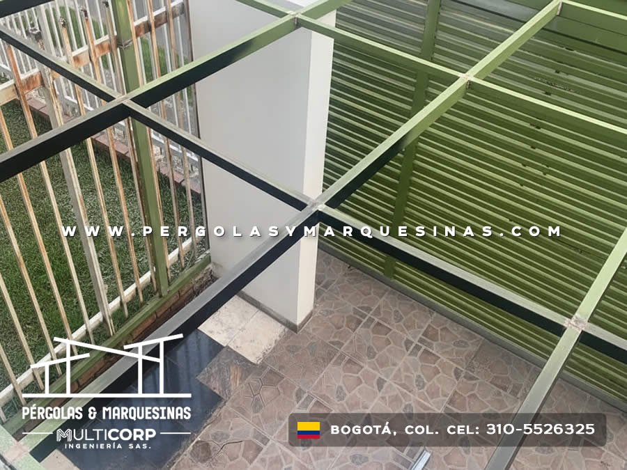 Cubierta transparente con listones de madera y estructura metálica sobre patio residencial en Bogotá, Colombia. Multicorp Ingeniería SAS.