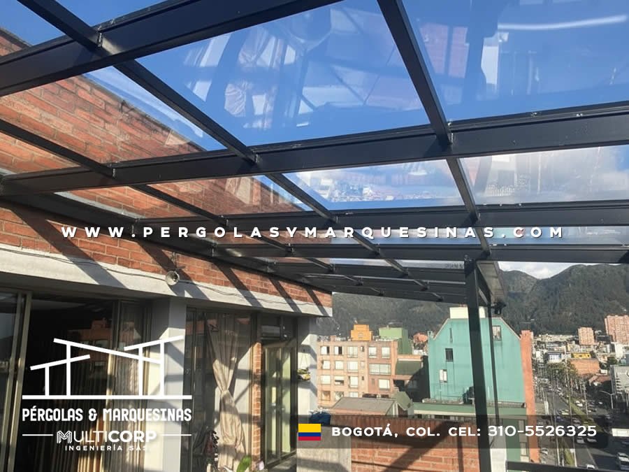 Techo de vidrio transparente con marco metálico negro montado sobre terraza de edificio en Bogotá, Colombia. Multicorp Ingeniería SAS.