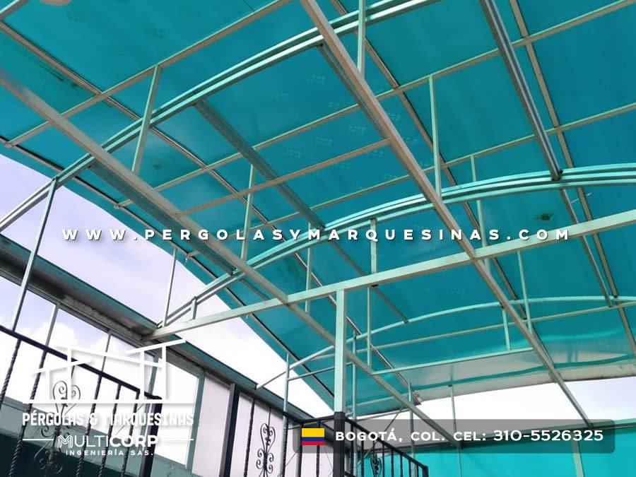 Techo de policarbonato azul translúcido con estructura metálica blanca para patio interior en Bogotá, Colombia. Multicorp Ingeniería SAS.