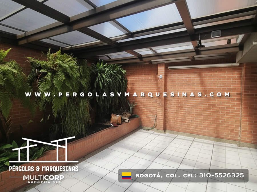 Pérgola metálica negra con techo de policarbonato translúcido y jardinera para patio residencial en Bogotá, Colombia. Multicorp Ingeniería SAS.