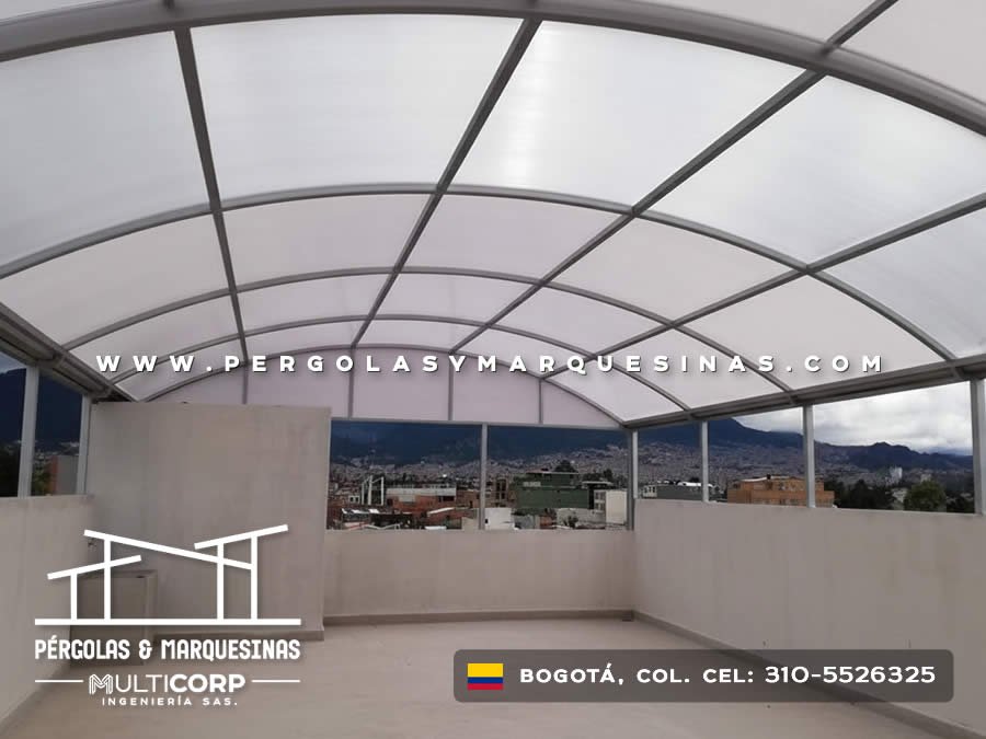 Domo arqueado de policarbonato translúcido con estructura metálica gris para terraza de apartamento en Bogotá, Colombia. Multicorp Ingeniería SAS.