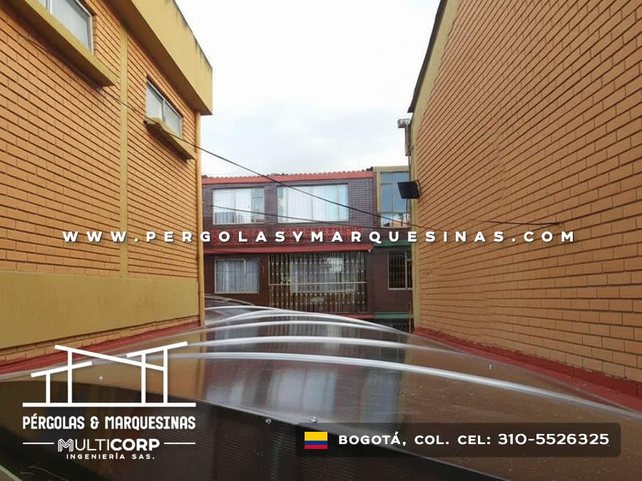 Patio interior descubierto entre muros de ladrillo con revestimiento horizontal de madera en edificio en Bogotá, Colombia. Multicorp Ingeniería SAS.
