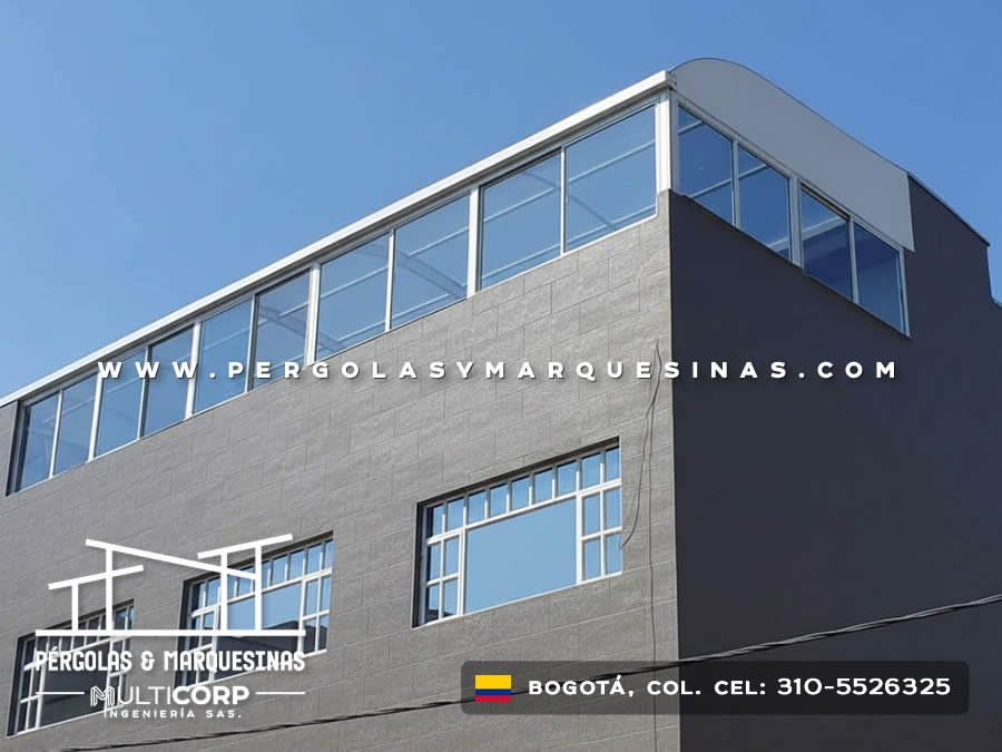 Cerramiento superior curvo de policarbonato con estructura metálica blanca para terraza de edificio moderno en Bogotá, Colombia. Multicorp Ingeniería SAS.