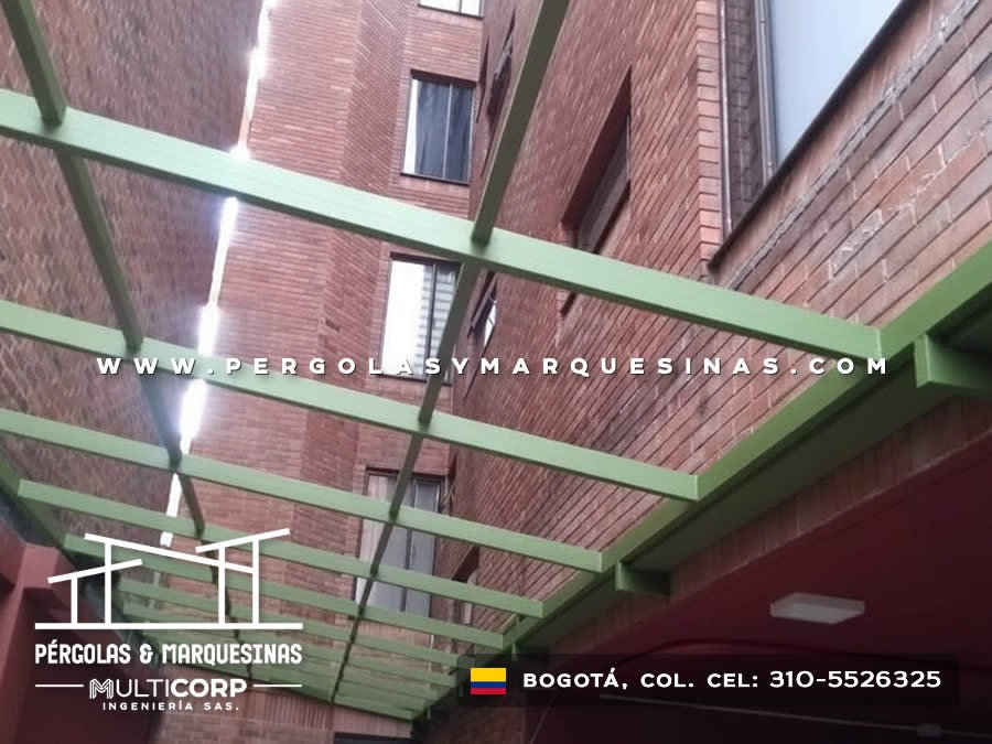 Estructura metálica verde sin cubierta instalada sobre patio de edificio residencial con muros de ladrillo en Bogotá, Colombia. Multicorp Ingeniería SAS.