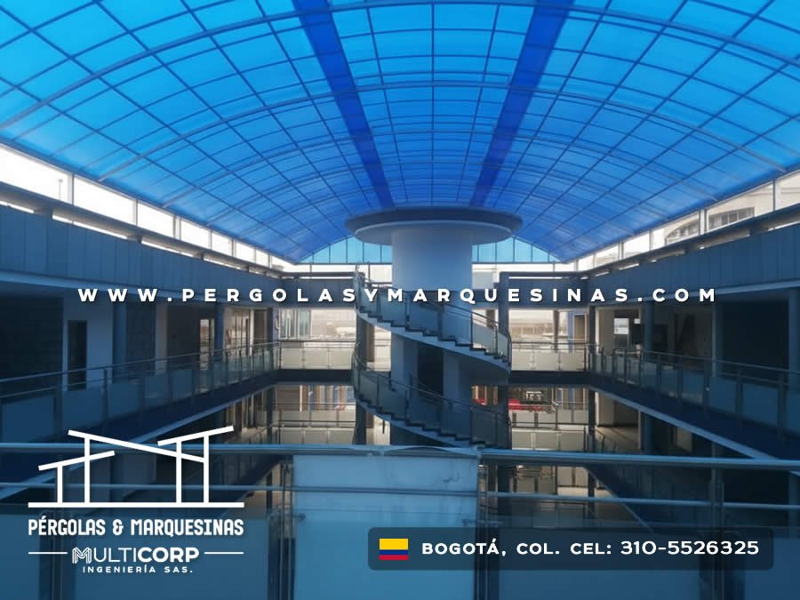 Domo curvo de policarbonato azul translúcido con estructura metálica para patio central de edificio en Bogotá, Colombia. Multicorp Ingeniería SAS.