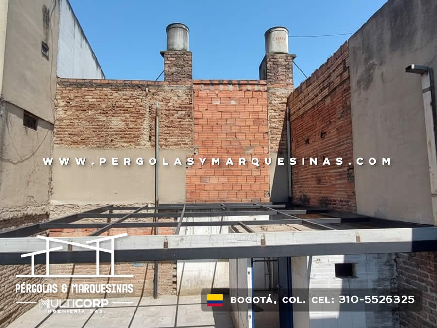 Estructura metálica blanca sin cubierta sobre patio descubierto entre medianeras de edificio en Bogotá, Colombia. Multicorp Ingeniería SAS.