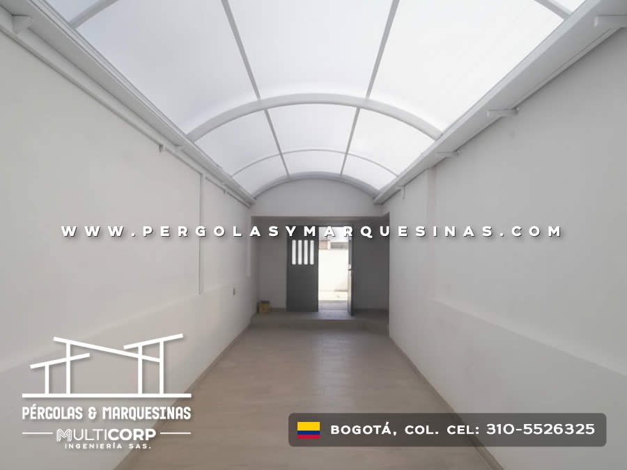 Domo curvo de policarbonato blanco opaco con estructura metálica para corredor interior de edificio en Bogotá, Colombia. Multicorp Ingeniería SAS.
