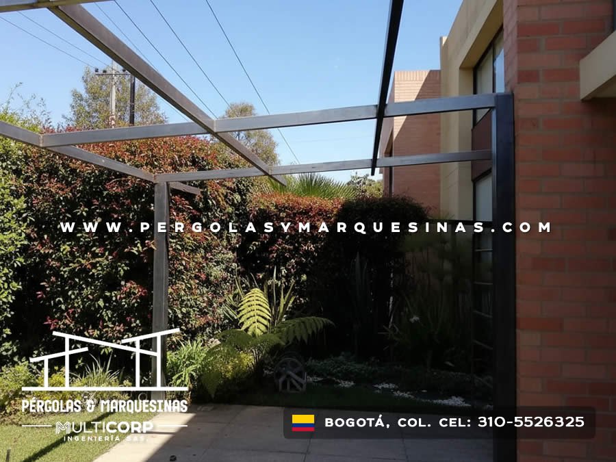 Pérgola metálica negra con techo de vidrio transparente para terraza con jardín vertical en Bogotá, Colombia. Multicorp Ingeniería SAS.