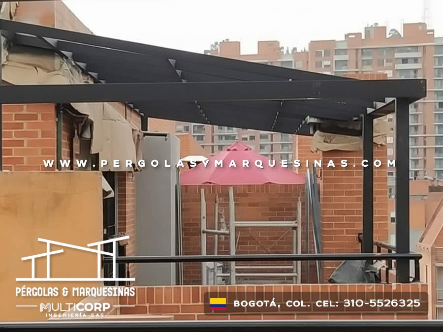 Pérgola metálica negra con toldo retráctil oscuro para terraza de apartamento en edificio en Bogotá, Colombia. Multicorp Ingeniería SAS.
