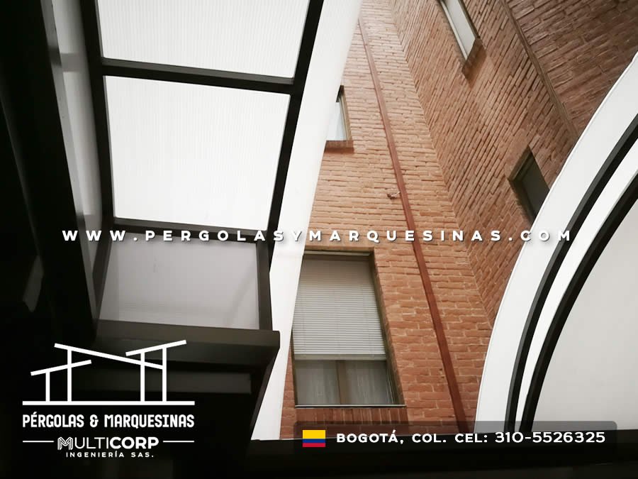 Estructura curva en policarbonato sobre metal junto a pared de ladrillo en Bogotá, Colombia. Multicorp Ingeniería SAS. Estructura curva en policarbonato sobre metal junto a pared de ladrillo en Bogotá, Colombia. Multicorp Ingeniería SAS.