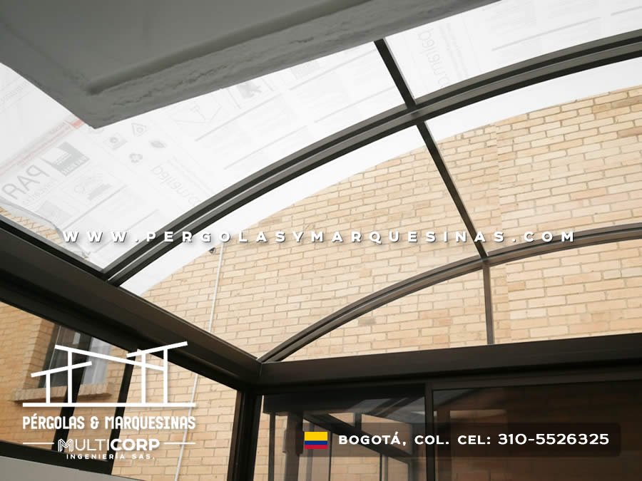 Pérgola curva en policarbonato sobre metal en entrada con pared de ladrillo en Bogotá, Colombia. Multicorp Ingeniería SAS. Pérgola curva en policarbonato sobre metal en entrada con pared de ladrillo en Bogotá, Colombia. Multicorp Ingeniería SAS.