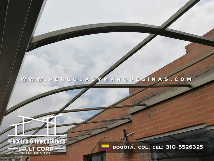 Pérgola abierta en arcos de metal curvo sobre azotea junto a pared de ladrillo en Bogotá, Colombia. Multicorp Ingeniería SAS. Pérgola abierta en arcos de metal curvo sobre azotea junto a pared de ladrillo en Bogotá, Colombia. Multicorp Ingeniería SAS.