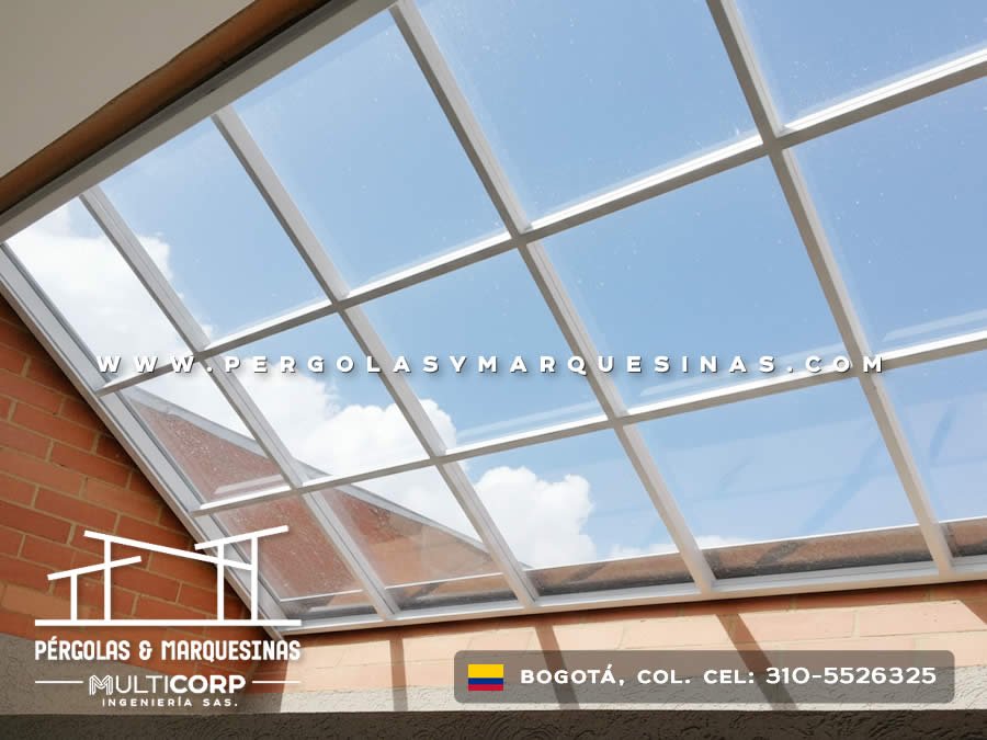 Techo transparente de policarbonato con perfiles metálicos blancos sobre patio interior en Bogotá, Colombia. Multicorp Ingeniería SAS.