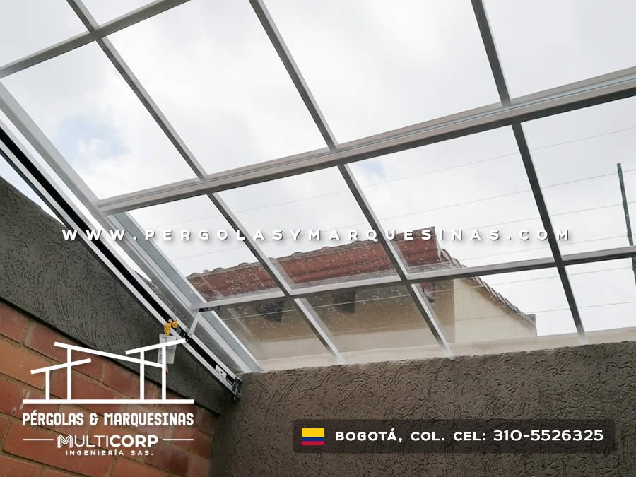 Techo de policarbonato con estructura metálica gris sobre patio entre muros de ladrillo en Bogotá, Colombia. Multicorp Ingeniería SAS.
