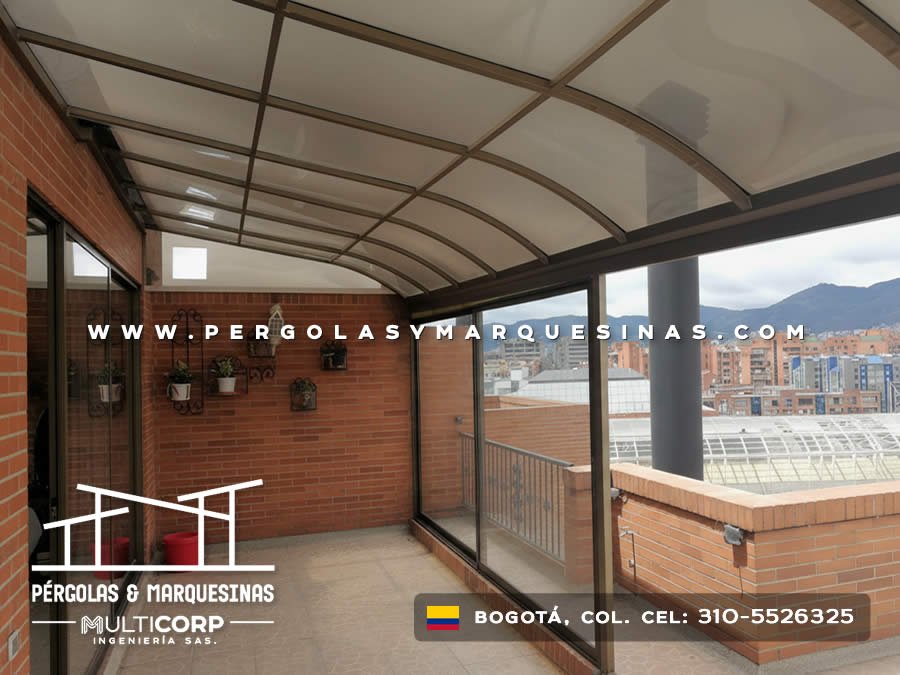 Cerramiento con techo curvo de policarbonato y ventanales de vidrio en balcón con vista panorámica en Bogotá, Colombia. Multicorp Ingeniería SAS.