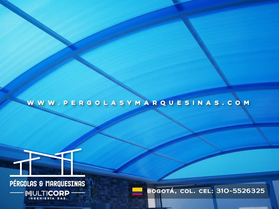 Techo curvo de policarbonato azul con arcos metálicos sobre espacio interior en Bogotá, Colombia. Multicorp Ingeniería SAS.