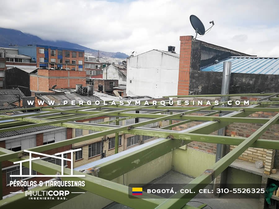 Pérgola con cubierta de lámina metálica y estructura verde en terraza con vista a los cerros en Bogotá, Colombia. Multicorp Ingeniería SAS.
