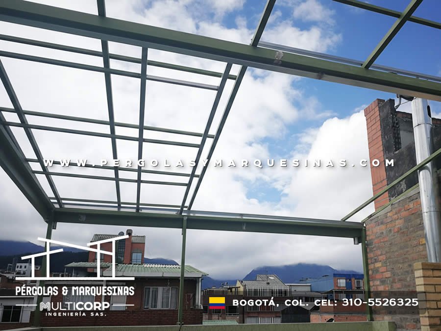 Pérgola metálica verde preparada para cubierta con vista a cerros nublados en Bogotá, Colombia. Multicorp Ingeniería SAS.