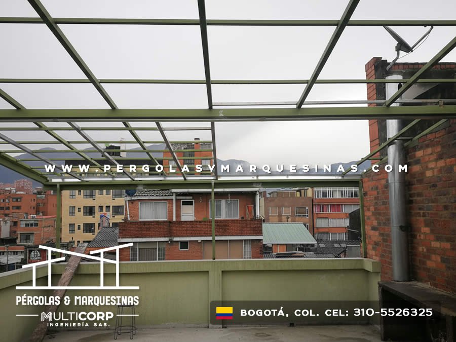 Estructura metálica de pérgola verde sobre terraza con vista urbana de edificios en Bogotá, Colombia. Multicorp Ingeniería SAS.