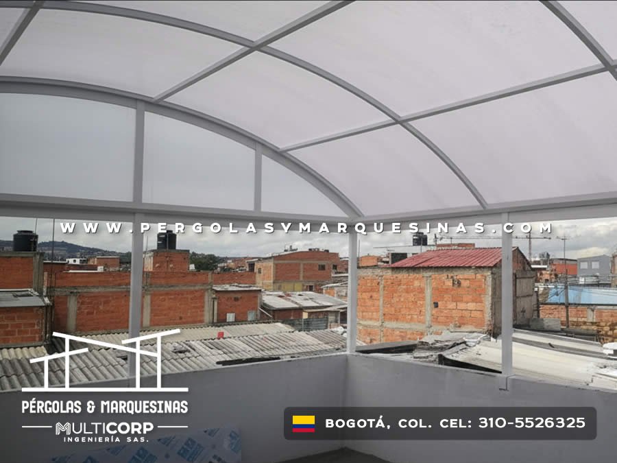 Domo curvo de policarbonato con estructura metálica sobre terraza residencial con vista urbana en Bogotá, Colombia. Multicorp Ingeniería SAS.