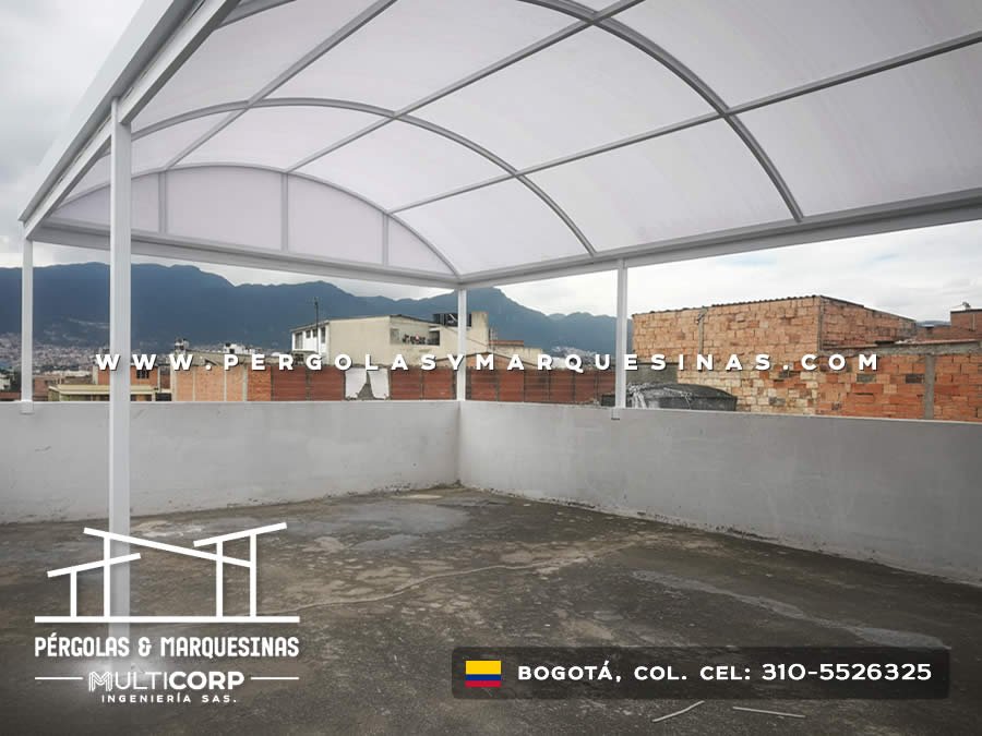 Cubierta curva de policarbonato con estructura blanca y vista panorámica de cerros en Bogotá, Colombia. Multicorp Ingeniería SAS.
