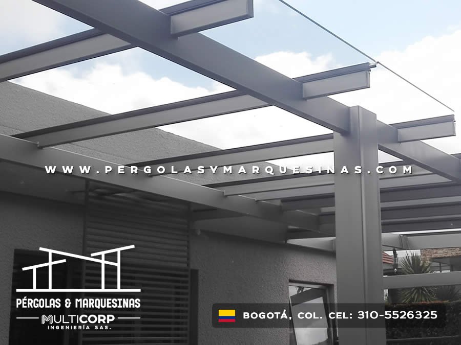 Pérgola de vidrio templado con estructura metálica gris sobre terraza moderna en Bogotá, Colombia. Multicorp Ingeniería SAS.