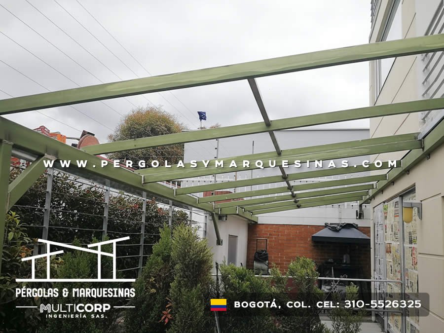 Estructura de pérgola metálica verde preparada sobre patio exterior con jardín en Bogotá, Colombia. Multicorp Ingeniería SAS.