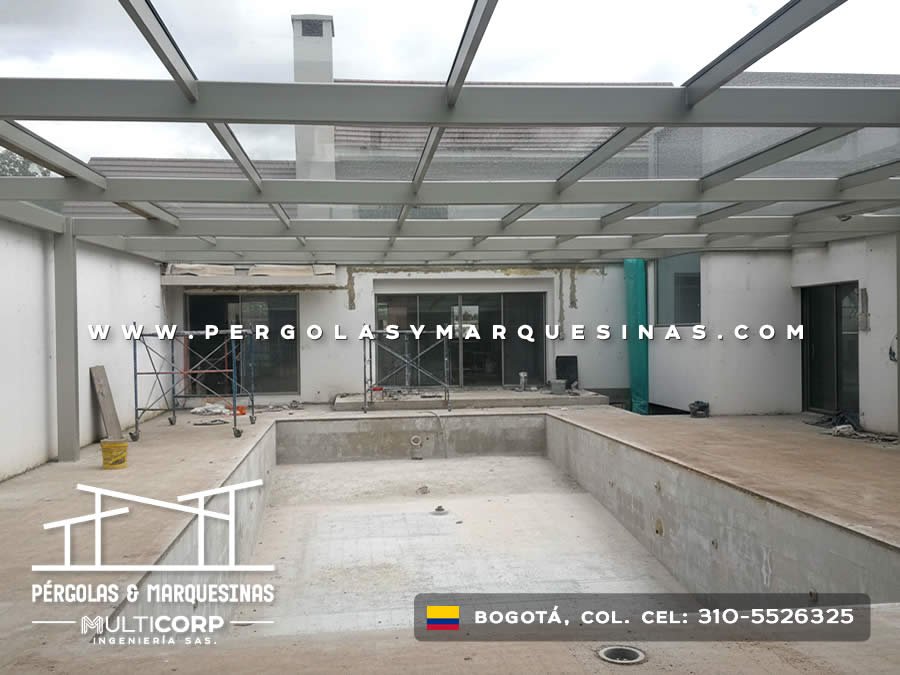 Pérgola de vidrio templado con estructura gris sobre zona de piscina en construcción en Bogotá, Colombia. Multicorp Ingeniería SAS.