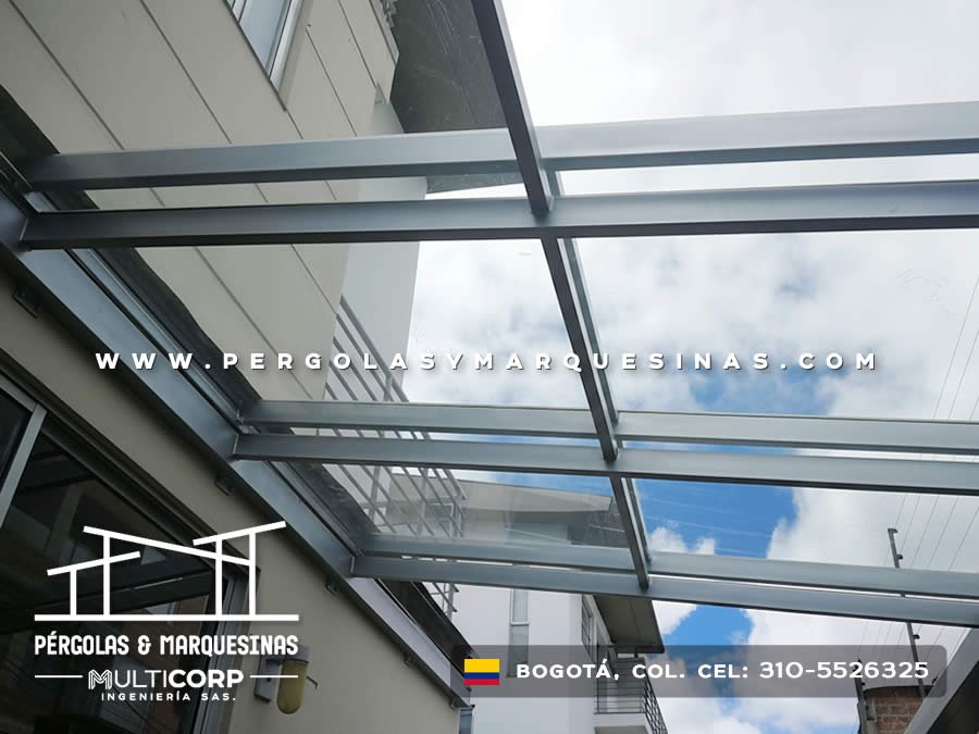 Pérgola de vidrio templado con perfiles metalicos sobre terraza con vista urbana en Bogotá, Colombia. Multicorp Ingeniería SAS.