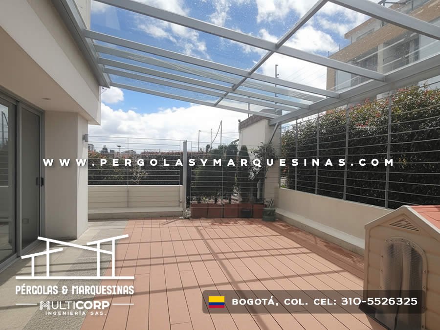 Techo de vidrio templado con estructura gris sobre terraza con deck y plantas en Bogotá, Colombia. Multicorp Ingeniería SAS.
