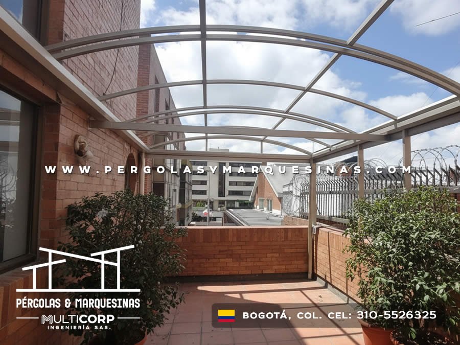 Estructura curva con techo translúcido y marco metálico sobre terraza con jardineras en edificio residencial en Bogotá, Colombia. Multicorp Ingeniería SAS.