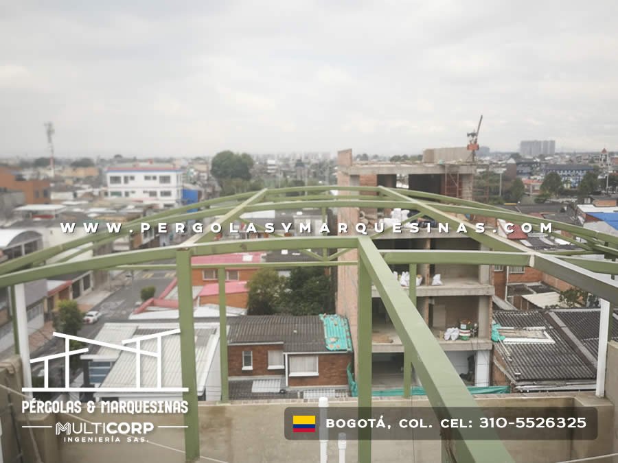Estructura metálica curva en verde para cubierta sobre terraza en edificio residencial en Bogotá, Colombia. Multicorp Ingeniería SAS.