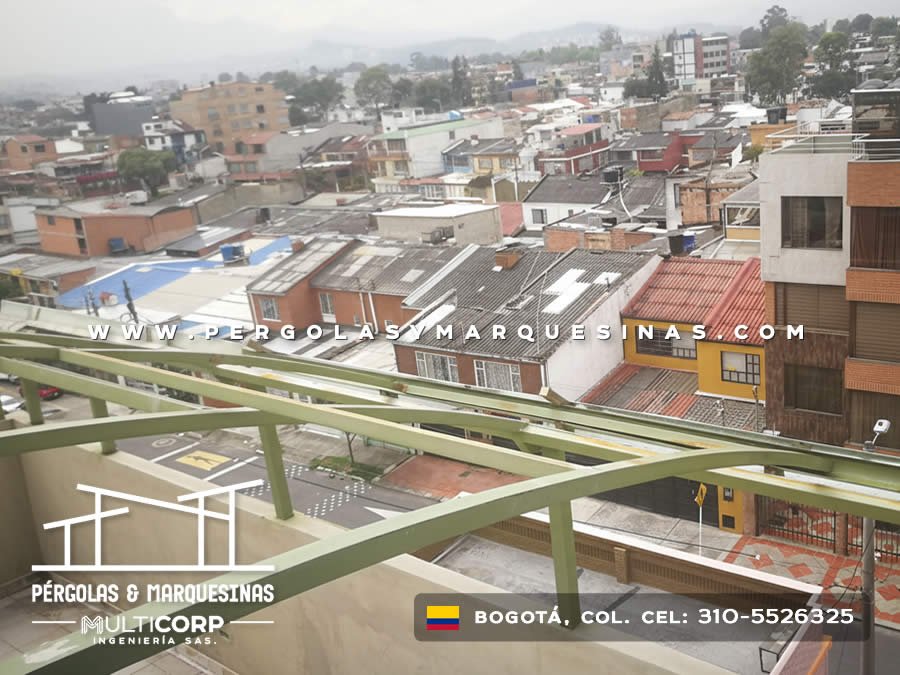 Armazón metálico curvo en verde para cubierta sobre terraza en edificio residencial urbano en Bogotá, Colombia. Multicorp Ingeniería SAS.
