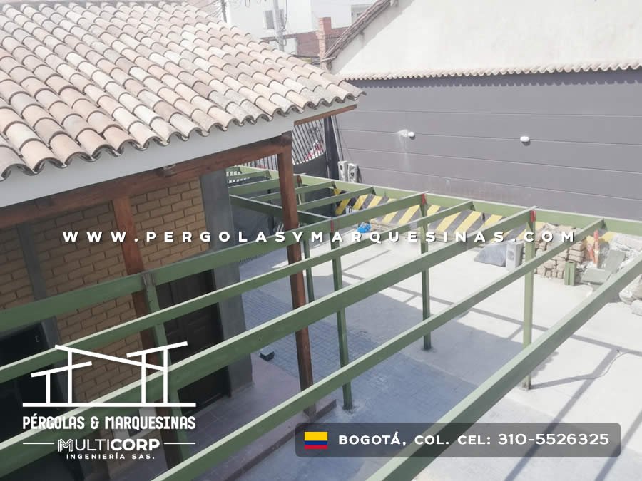 Estructura metálica verde en terraza de edificio con techo de teja y paredes de ladrillo en Bogotá, Colombia. Multicorp Ingeniería SAS. Estructura metálica verde en terraza de edificio con techo de teja y paredes de ladrillo en Bogotá, Colombia. Multicorp Ingeniería SAS.