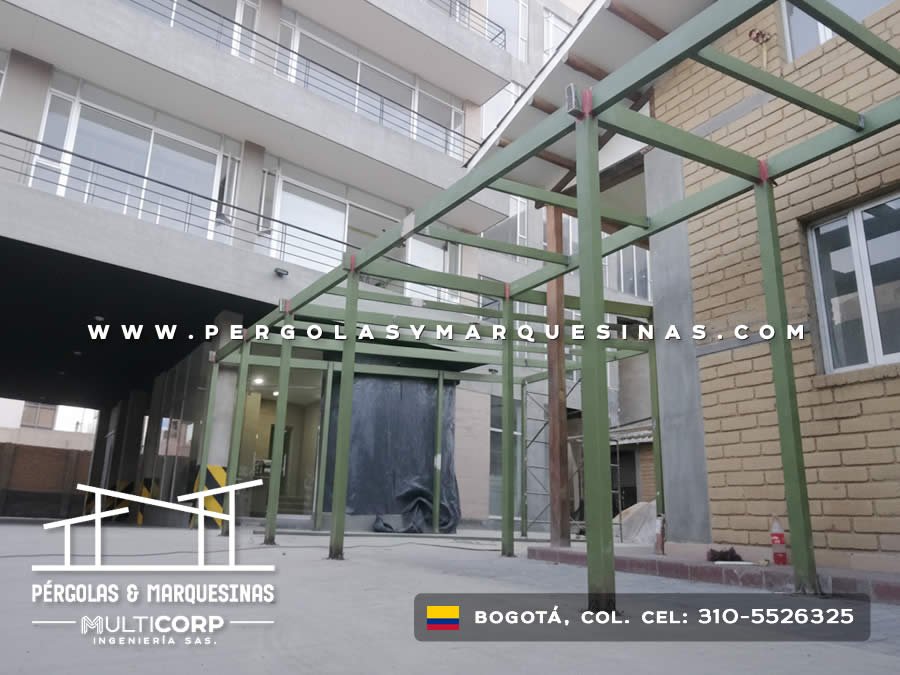 Marquesina metálica verde en construcción sobre terraza entre edificios urbanos en Bogotá, Colombia. Multicorp Ingeniería SAS. Marquesina metálica verde en construcción sobre terraza entre edificios urbanos en Bogotá, Colombia. Multicorp Ingeniería SAS.